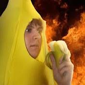 A man in a banana costume, eating a banana. Behind him, fire is raging.
